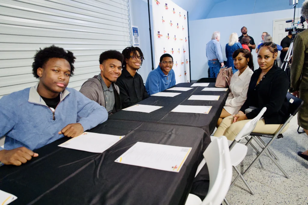 Seven Teens sitting at a table.
